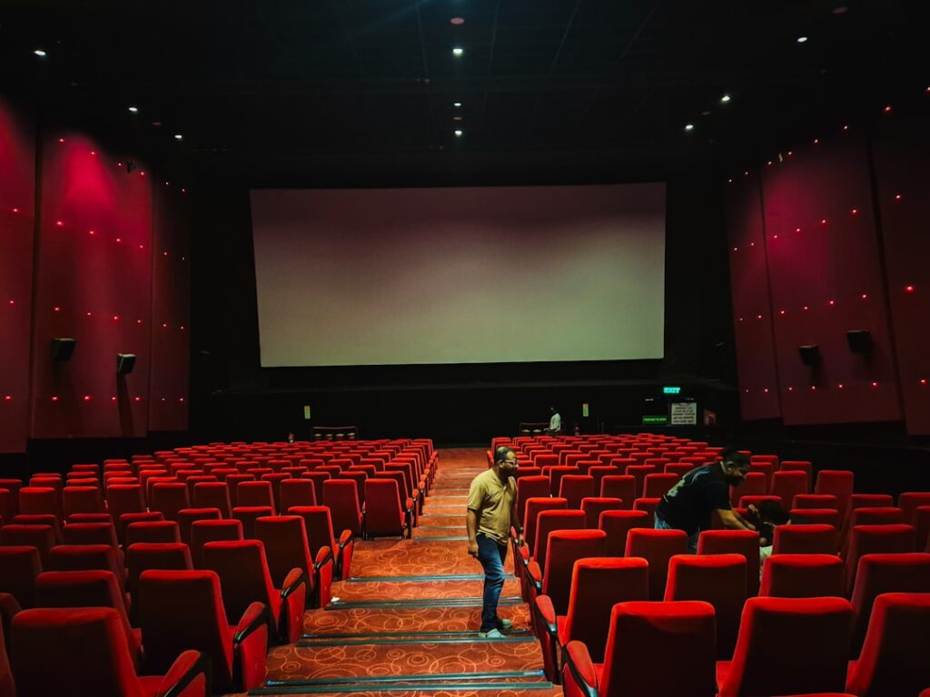 Empty cinema hall with red seats and a large screen